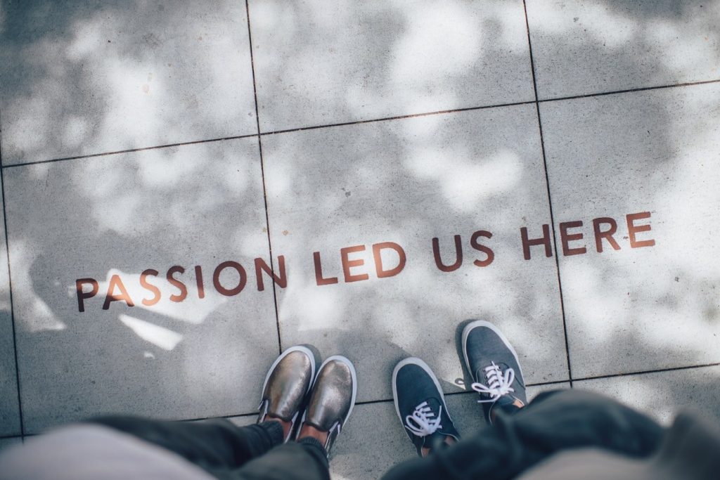[Image of a street with two people's feet with words saying 'Passion led us here']