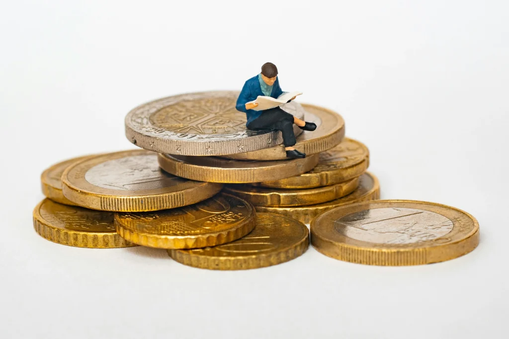 Stacks of coins with a small figure sitting on top.